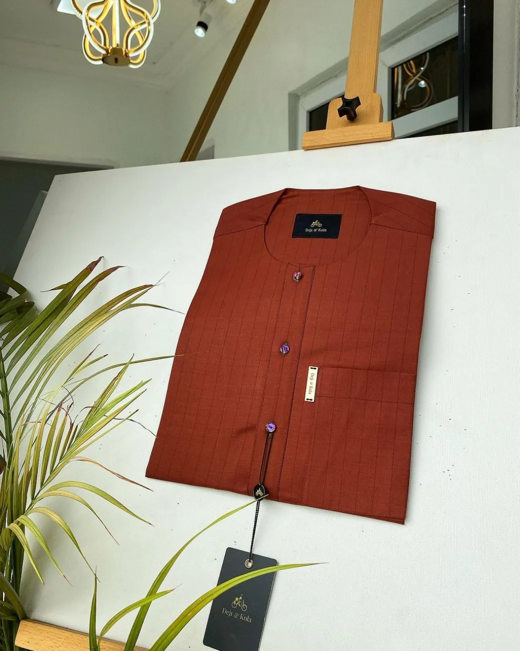 A black stripe and burnt orange African kaftan with gold buttons detailing and sokoto