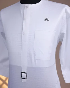 A Bright white, front flap with Swarovski button & metal tag details, 3/4 sleeve African kaftan.