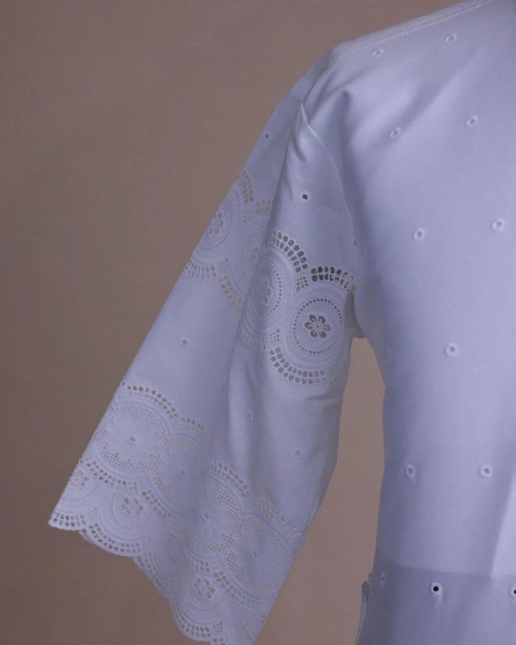 A bright white, Swiss patterned lace, front flap with side pattern, Swarovski button, 3/4 sleeve African kaftan native.