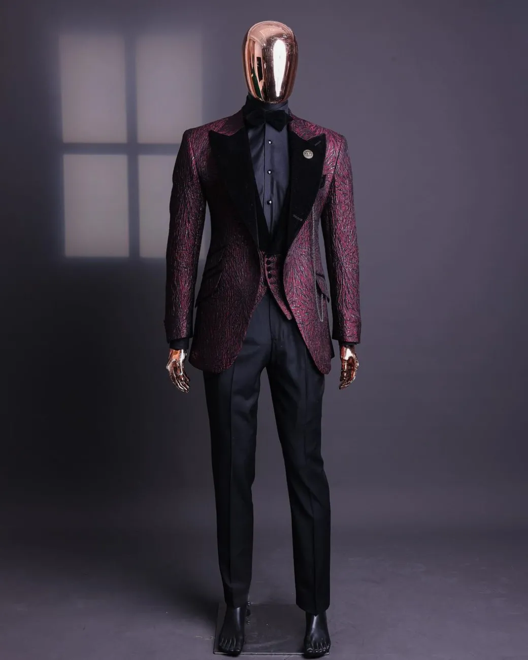 A burgundy, black broom splashed metallic jacquard, knitted, peak lapel tuxedo suit