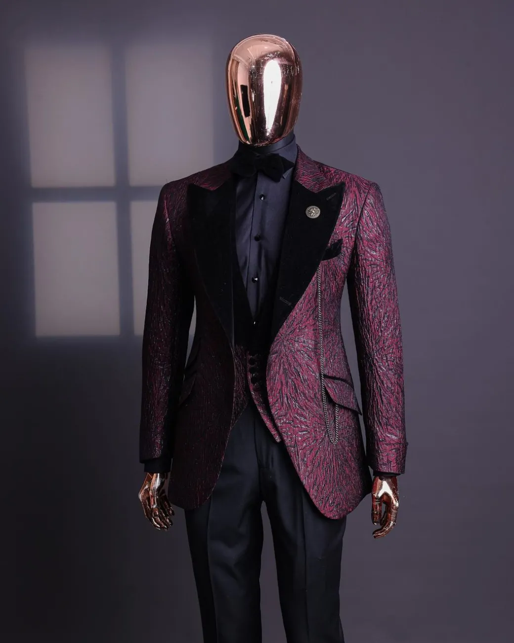 A burgundy, black broom splashed metallic jacquard, knitted, peak lapel tuxedo suit