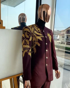 A burgundy safari suit with gold floral pattern embroidery detailing