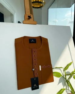 A caramel brown flap and pocket undulating with connected lane embroidery detailing African traditional senator Kaftan native