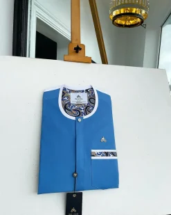 A cerulean blue, vertical flap with horizontal paisley patch pocket detailing and a Swarovski button African traditional senator kaftan native