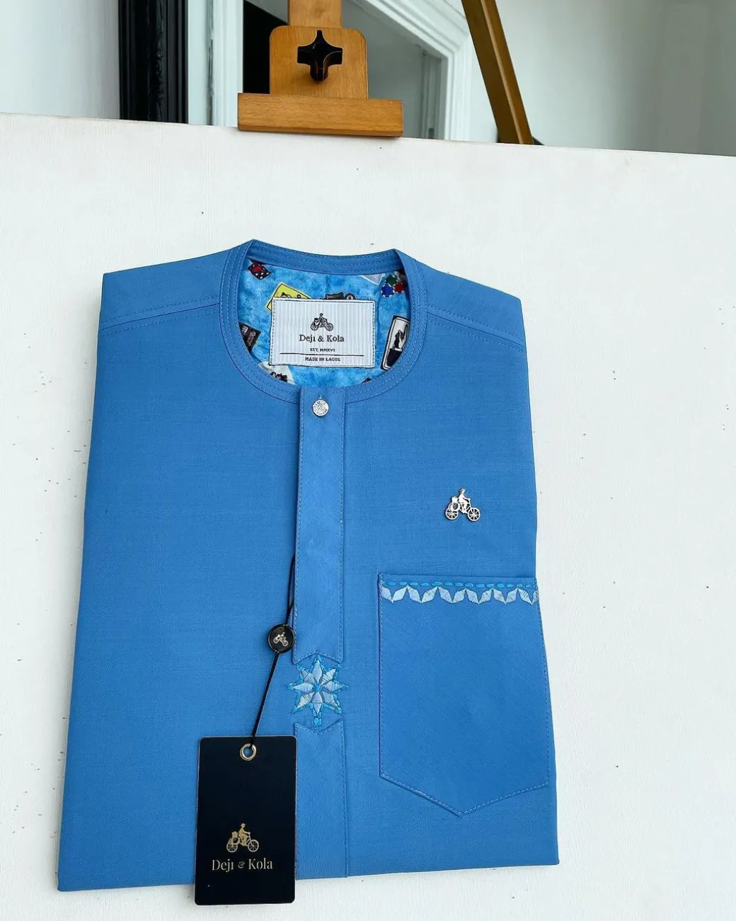 A cerulean blue, vertical Flap with Swarovski button on flap, related embroidery detailing African traditional senator kaftan native.