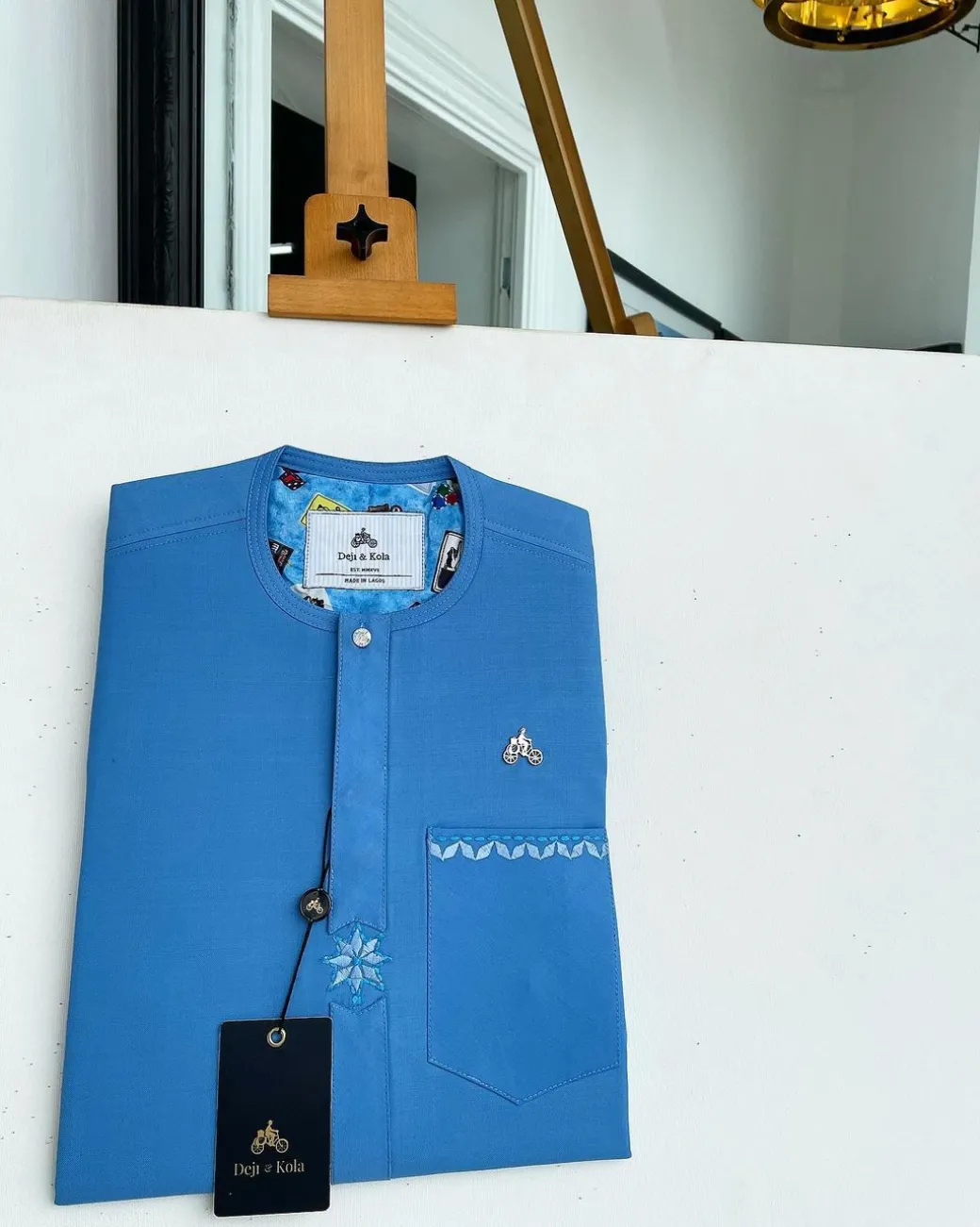 A cerulean blue, vertical Flap with Swarovski button on flap, related embroidery detailing African traditional senator kaftan native.
