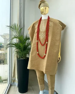 A champagne gold aso oke dashiki, with a floral and ancient style shaped embroidery design, hand woven Yoruba hat, an extra length red and gold coral bead.