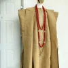 A champagne gold aso oke regal agbada, dashiki, sokoto, red and gold mix coral bead, matching hand woven Yoruba hat, and a long gold chain with a Jesus piece.