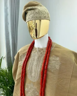 A champagne gold aso oke dashiki, with a floral and ancient style shaped embroidery design, hand woven Yoruba hat, an extra length red and gold coral bead.