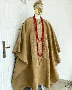 A champagne gold aso oke regal agbada, dashiki, sokoto, red and gold mix coral bead, matching hand woven Yoruba hat, and a long gold chain with a Jesus piece.