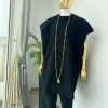 A charcoal black aso dashiki with a floral and box-shaped embroidery design, a hand-weaved Yoruba hat, and a gold Jesus timepiece