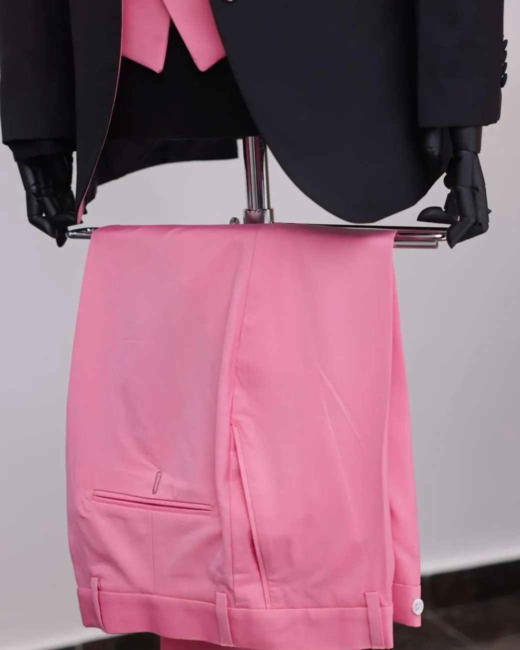 A charcoal black “contrast” pink notch lapel suit