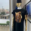 A charcoal black “daftan” with a tiger prints & black Fulani hat