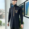 A charcoal black, dotted flap, kissing wave embroidery detailing hat and flap pocket traditional senator kaftan native
