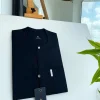 A Charcoal black front flap, interconnected embroidery, and a Swarovski button detail African traditional senator Kaftan native.