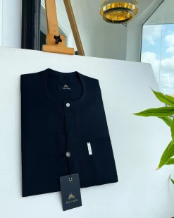 A Charcoal black front flap, interconnected embroidery, and a Swarovski button detail African traditional senator Kaftan native.