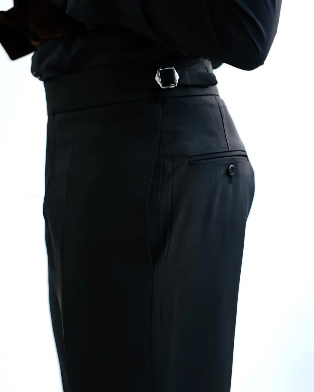 A Charcoal Black High Waist, Trumpet-Cut Details Pant With A Side Metal Adjuster.