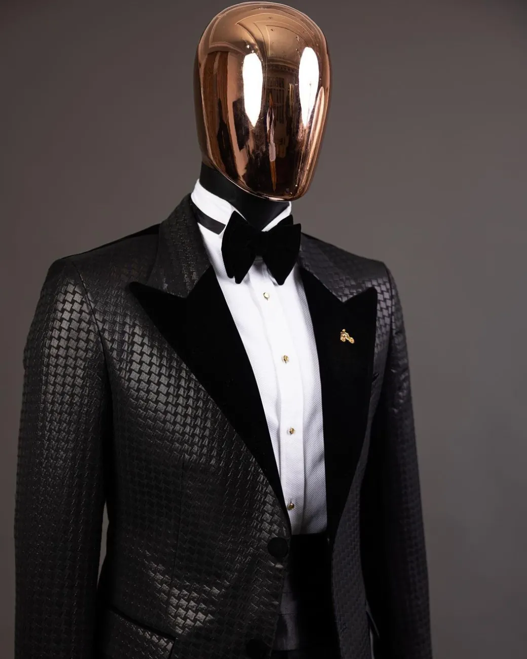 A Charcoal black inverted square patterned metallic jacquard tuxedo with charcoal black velvet peak lapel suit