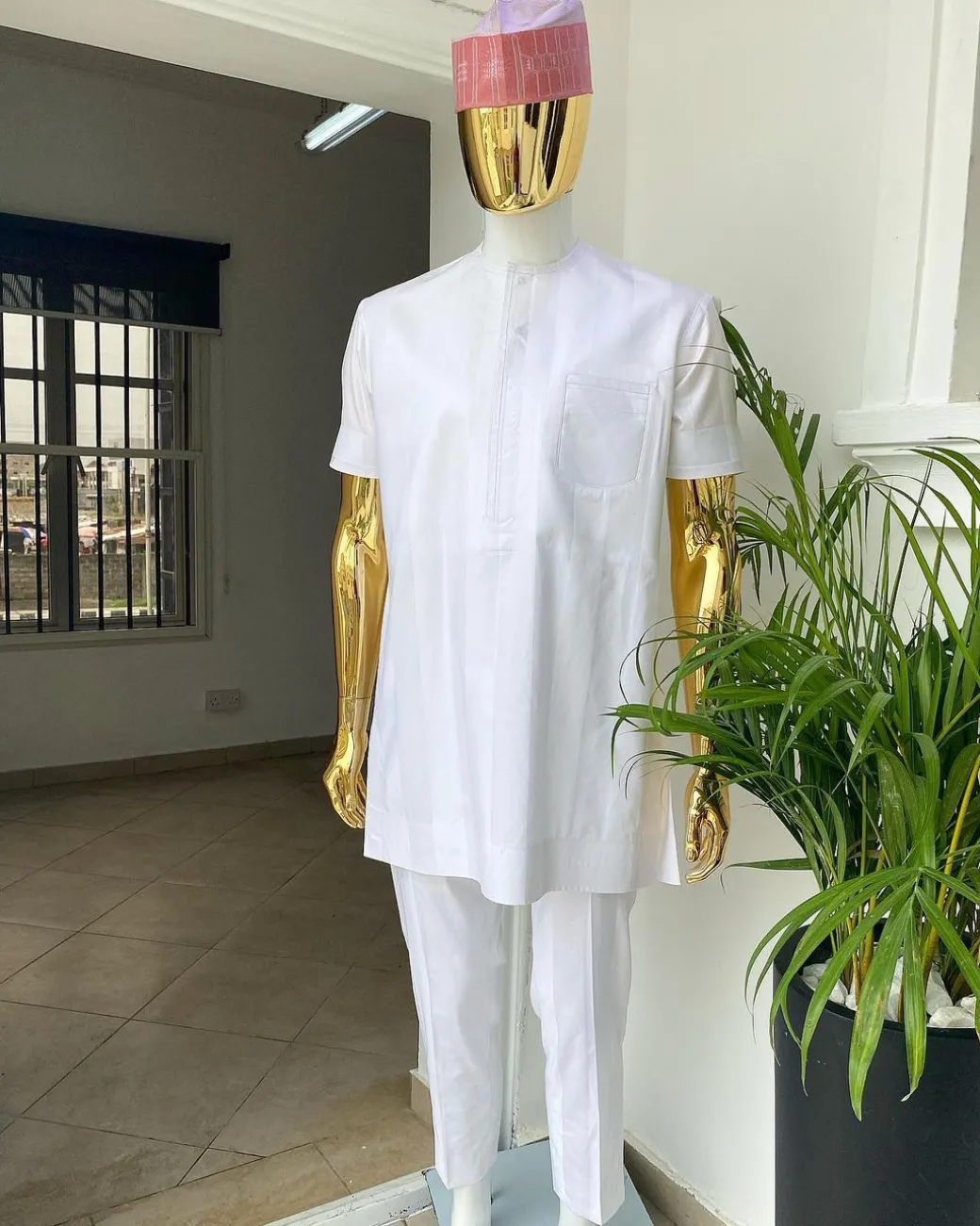 A Cocaine white voil short sleeve men’s tailored senator kaftan with a light weave pink kanuri hat
