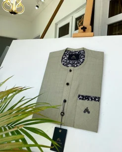 A Dark cream African kaftan with a clear view of Swarovski and buttons with paisley detailing