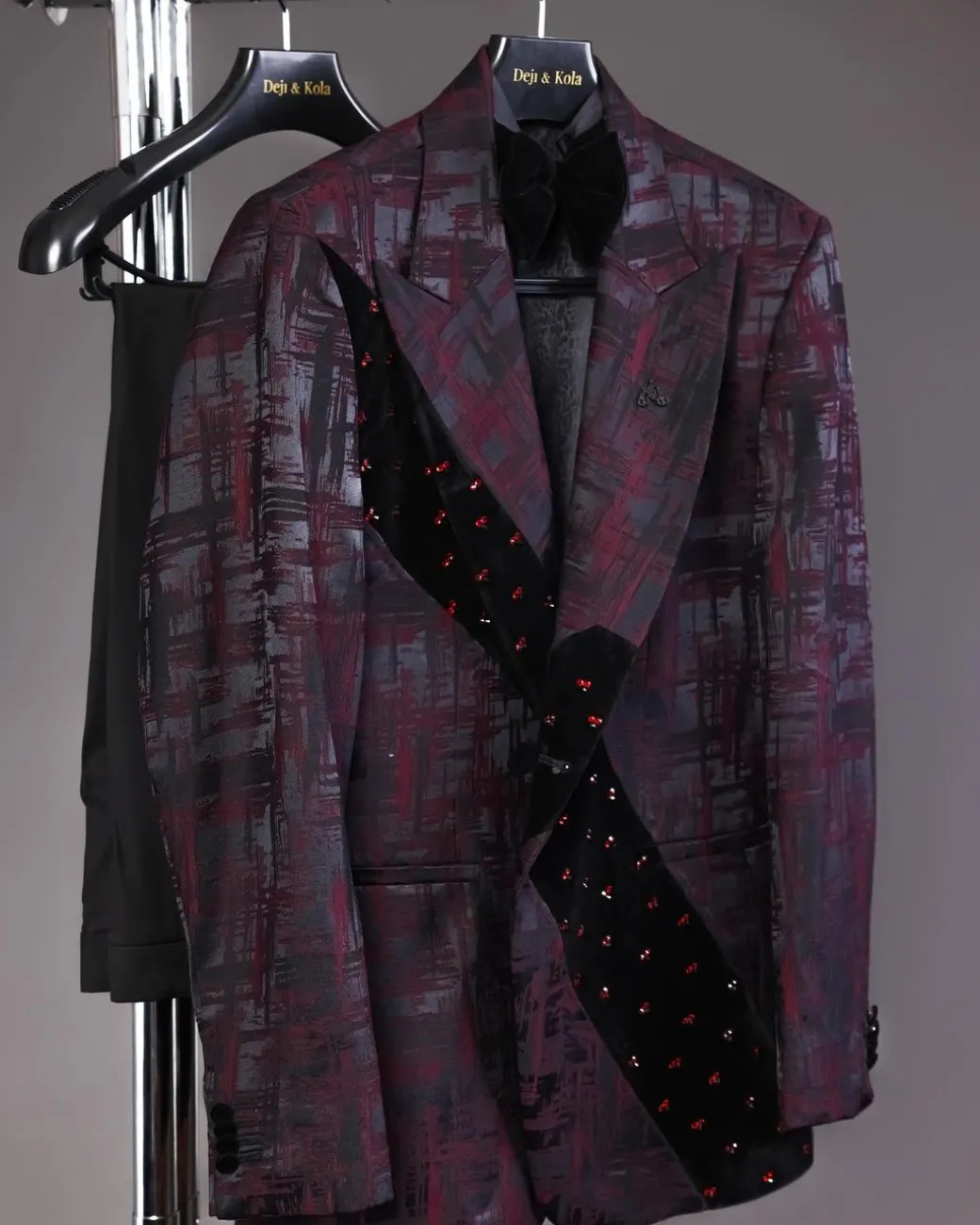 A diagonal cut layered black velvet Swarovski detailing burgundy and black patterned suit
