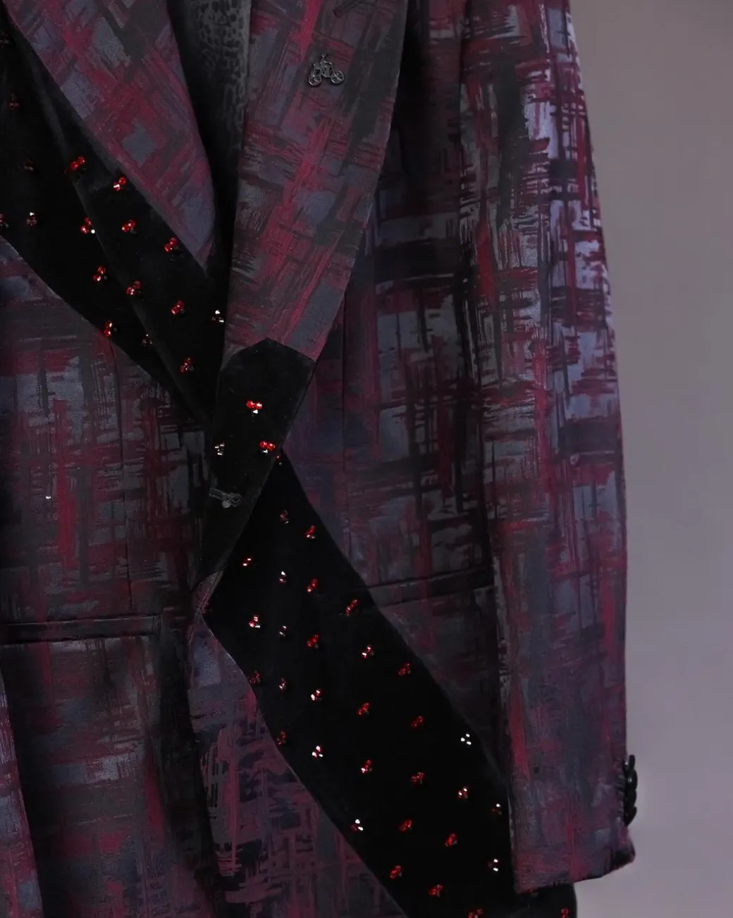 A diagonal cut layered black velvet Swarovski detailing burgundy and black patterned suit