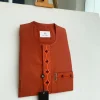A fire orange, flap and front pocket undulating with connected lane embroidery detailing african traditional senator kaftan native.