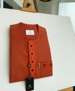 A fire orange, flap and front pocket undulating with connected lane embroidery detailing african traditional senator kaftan native.