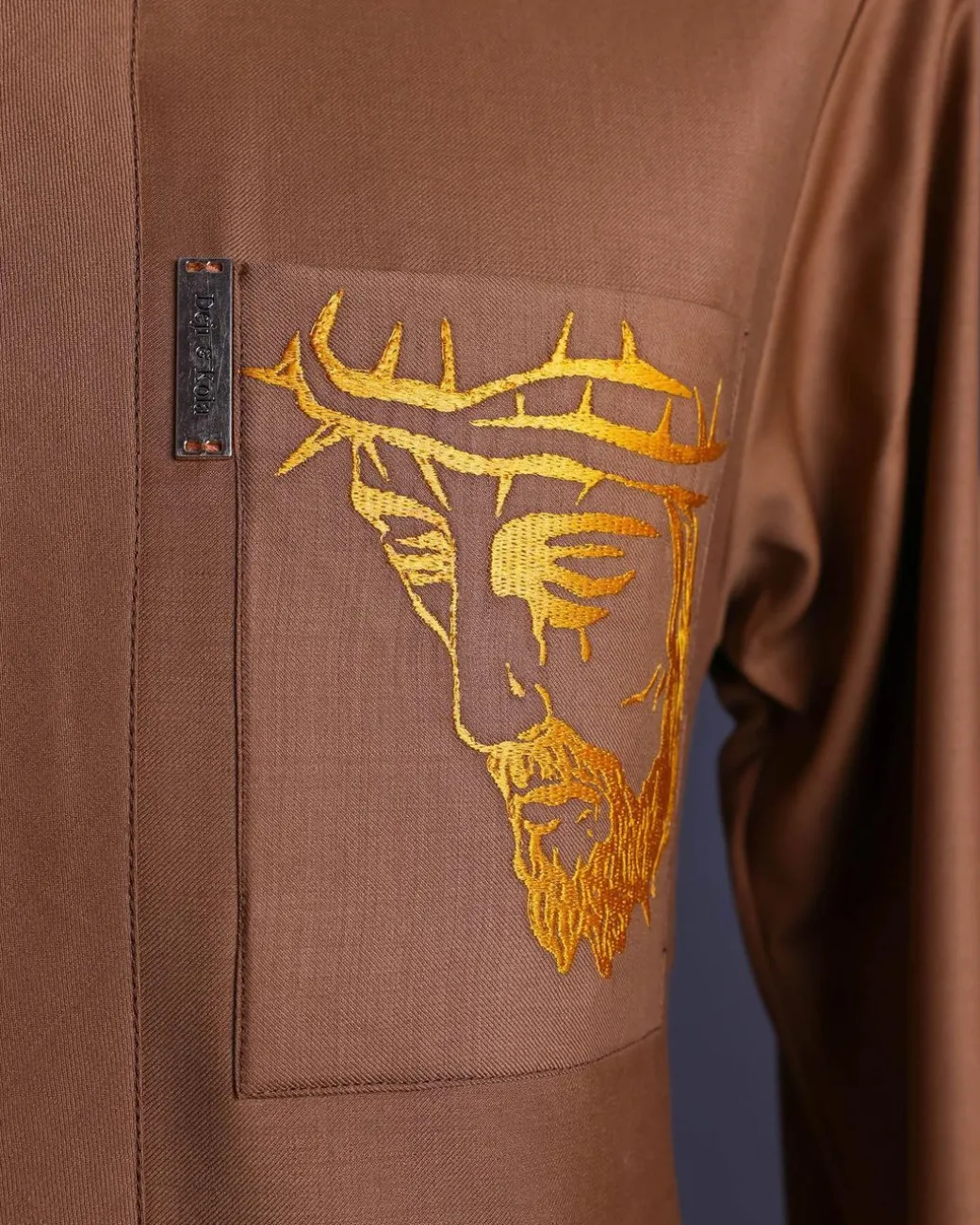 A Gingerbread brown, wide double lane flap, patch pocket with “Golgotha” embroidery detailing African senator kaftan native.