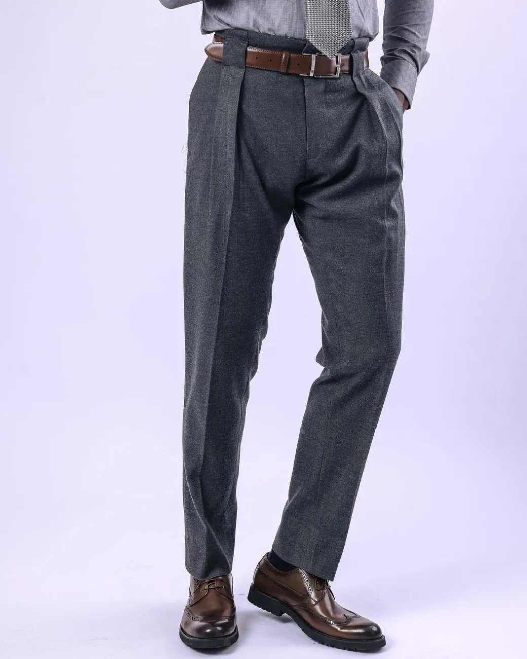 A Grey Gurkha pant with a covered belt tab and double pleats.