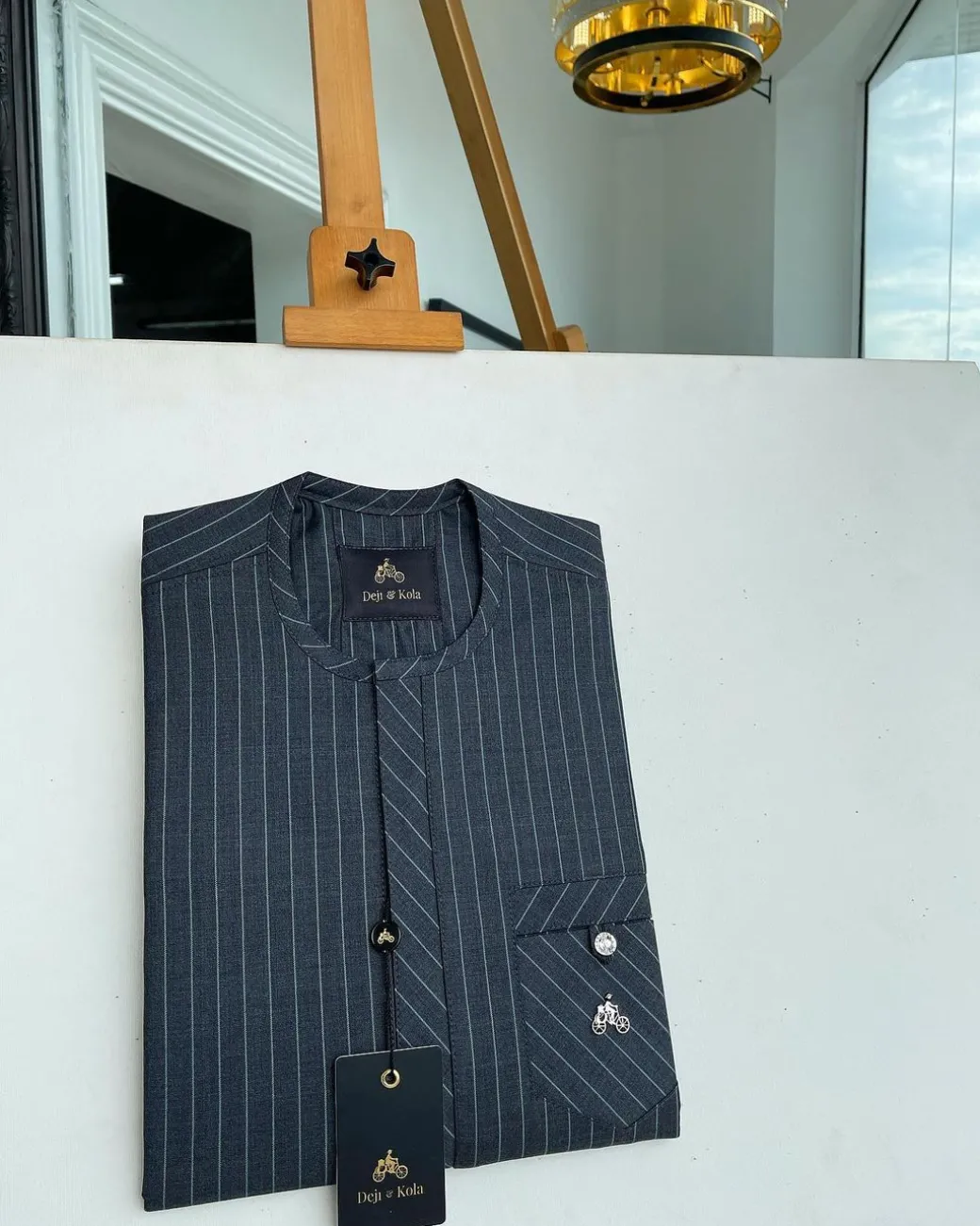 A grey pinstripe kaftan, front Flap with an inverse combat pocket Swarovski button details African traditional senator kaftan native.