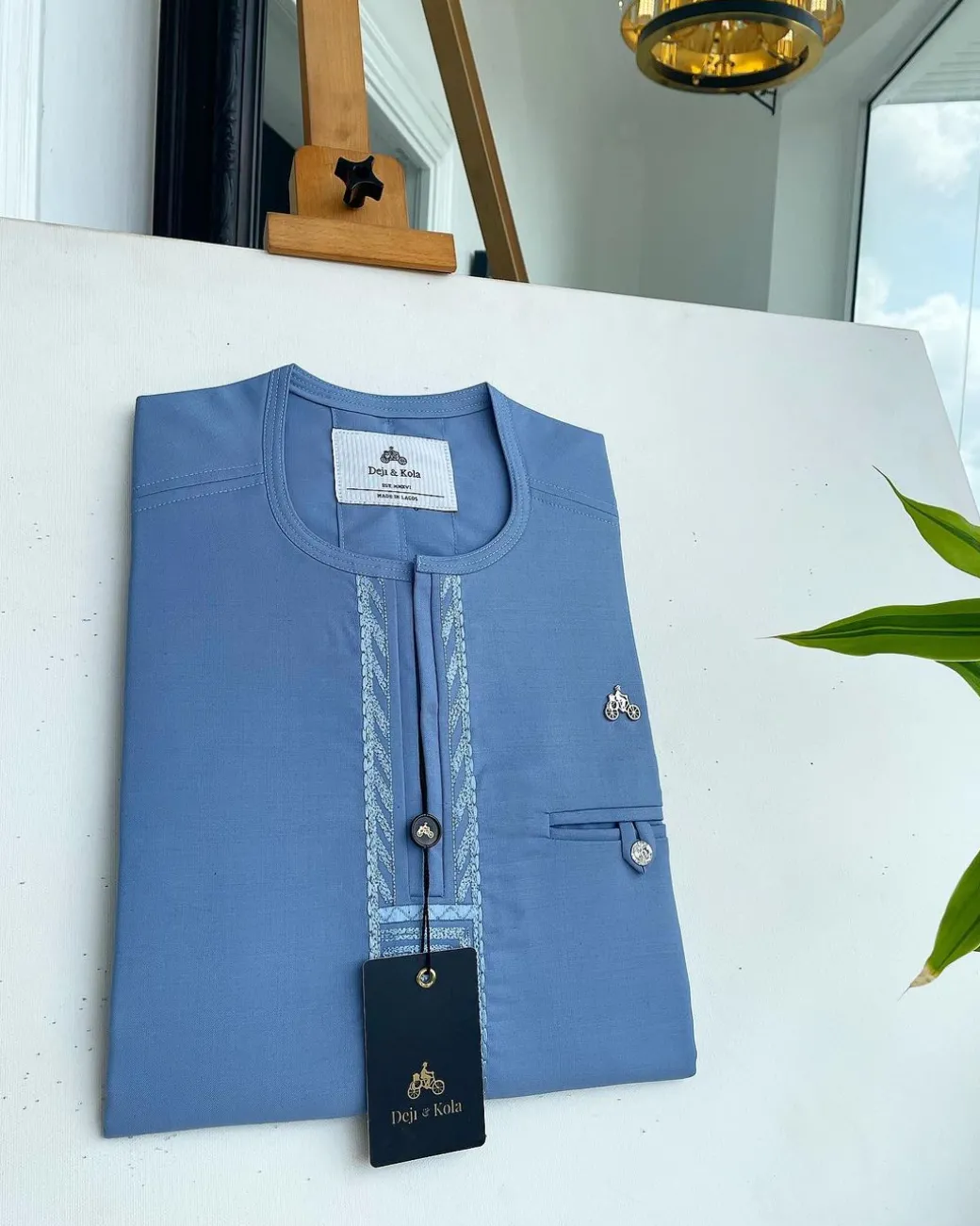 A Maya blue rail line flap with a combat pocket Swarovski button details African traditional senator Kaftan.