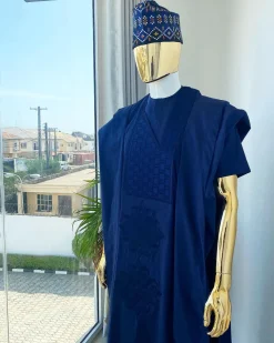 A navy blue aso oke dashiki with a floral and box-shaped embroidery design and hand-embroidered Yoruba hat
