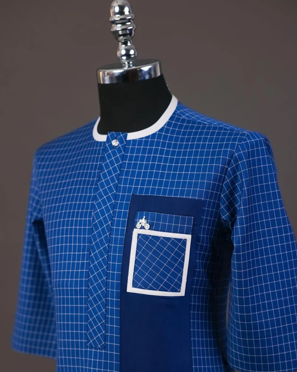 A Neon blue, graph check, front flap with Swarovski button details, and layered pocket traditional senator kaftan native