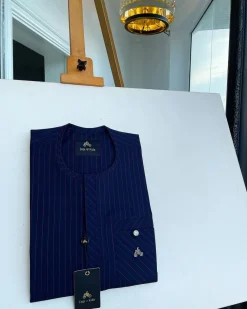 A pencil stripe midnight blue and red front flap with an inverse combat pocket Swarovski button details African traditional senator Kaftan native