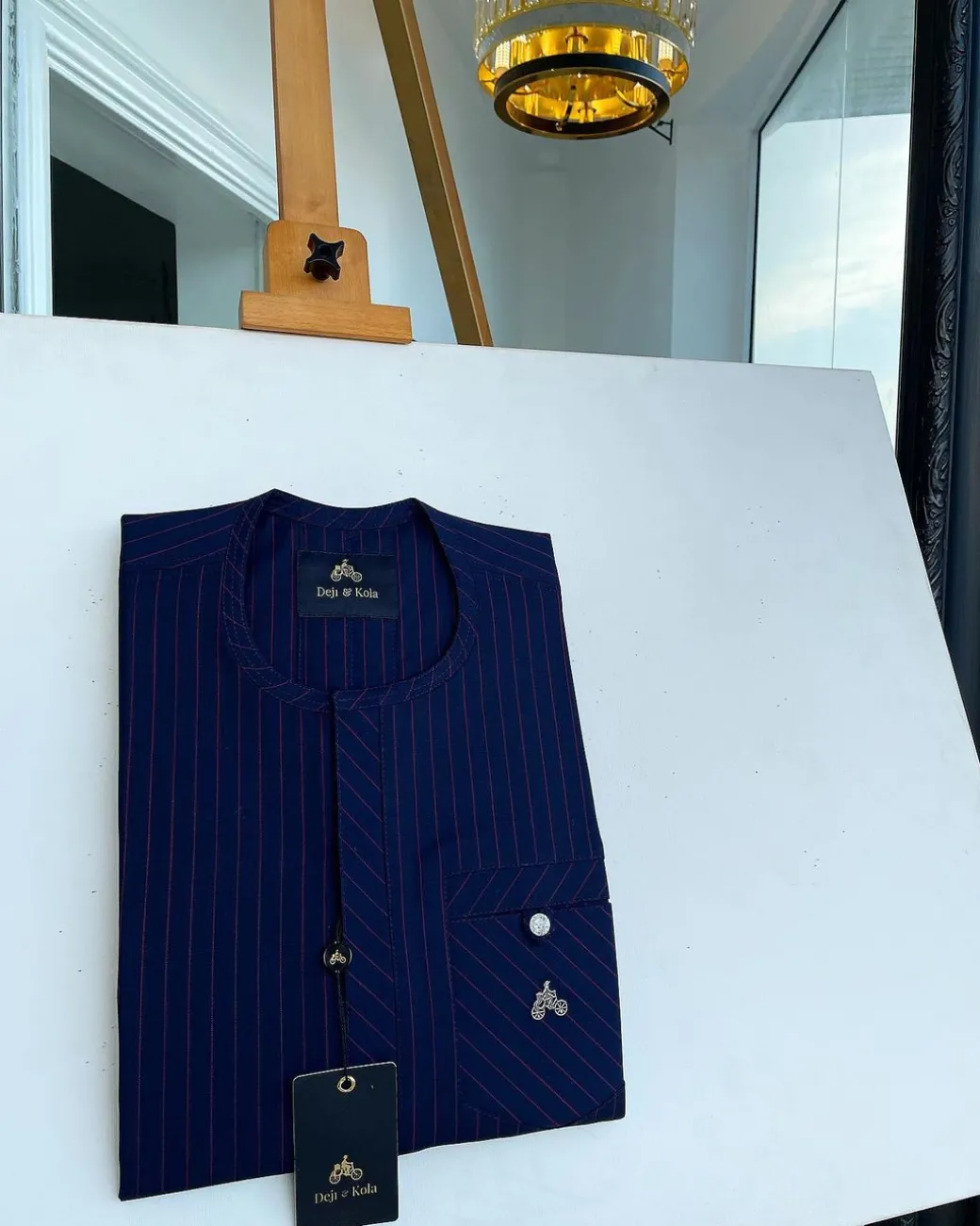 A pencil stripe midnight blue and red front flap with an inverse combat pocket Swarovski button details African traditional senator Kaftan native