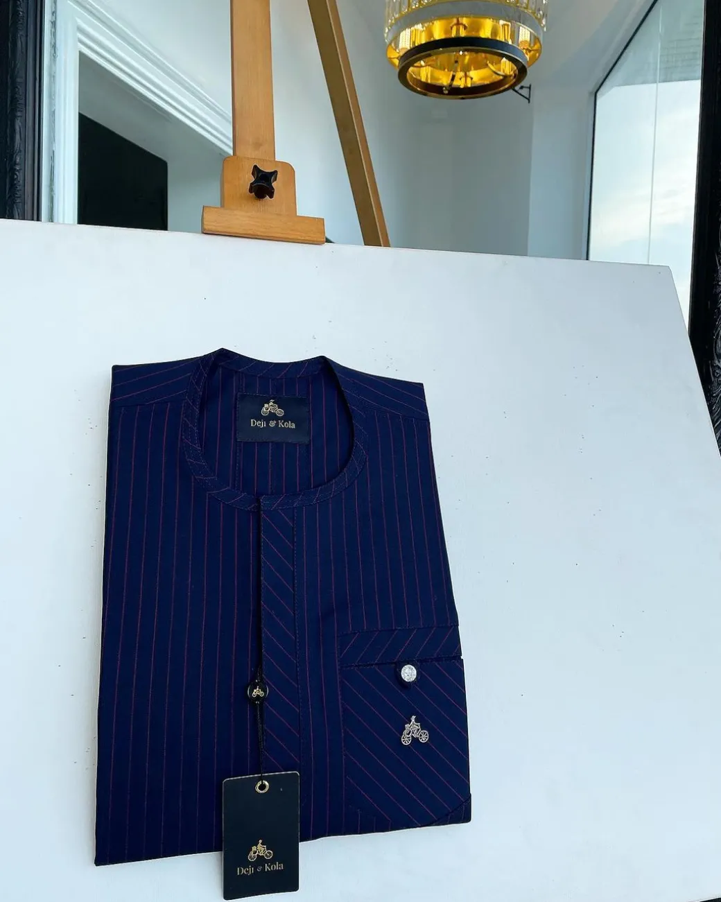 A pencil stripe midnight blue and red front flap with an inverse combat pocket Swarovski button details African traditional senator Kaftan native