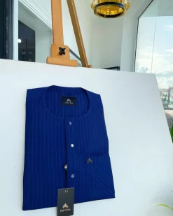 A pencil stripe, navy blue and Skye blue, front flap, blue and clear view Swarovski buttons, patch pocket detailing senator kaftan native.