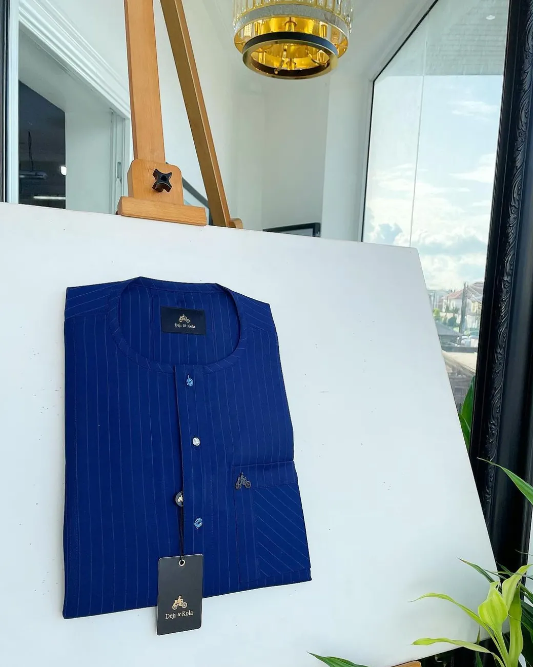 A pencil stripe, navy blue and Skye blue, front flap, blue and clear view Swarovski buttons, patch pocket detailing senator kaftan native.