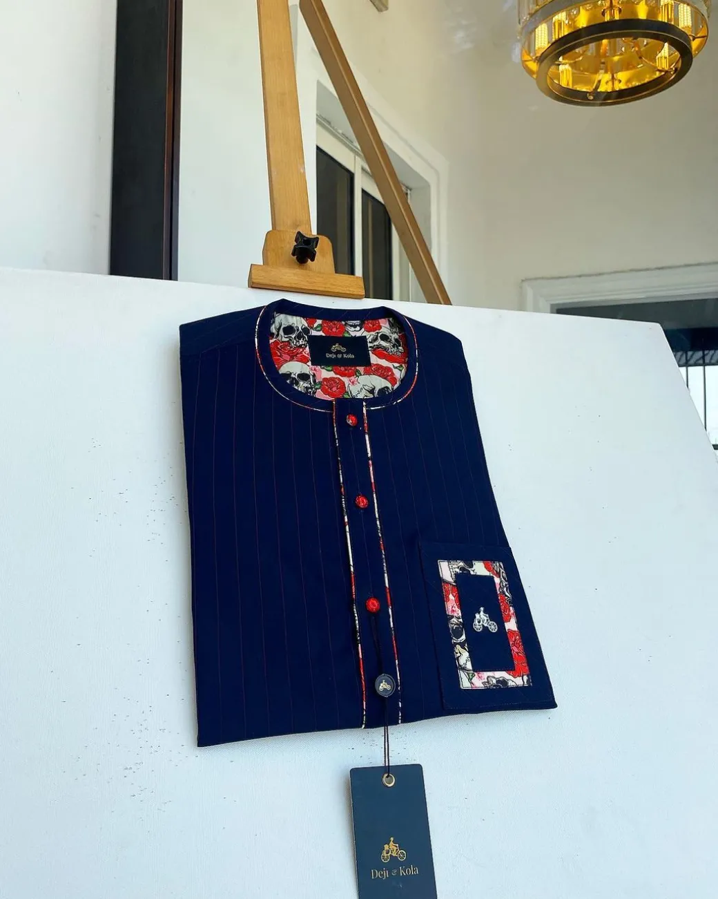A red and midnight blue pin stripe senators kaftan with mixed red paisley pocket and neck detailing.