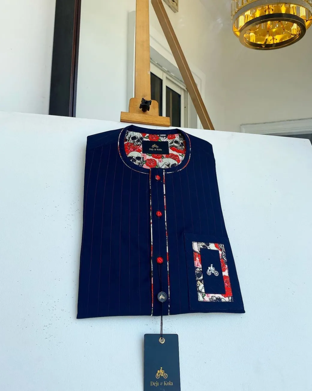 A red and midnight blue pin stripe senators kaftan with mixed red paisley pocket and neck detailing.