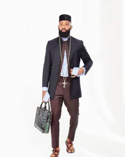 A Reloaded Ceremonial “Ayeye” Ijade 20/21 – Look 10- “Ajala”. A burgundy safari jacket with gold buttons, inner waist coat, turtle neck shirt, hat and pant trousers.