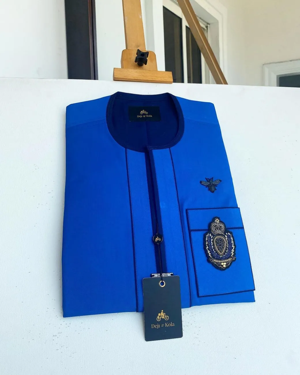 A Royal blue with navy blue mix, hand embroidery patch detailing, and black butterfly metal lapel African Kaftan