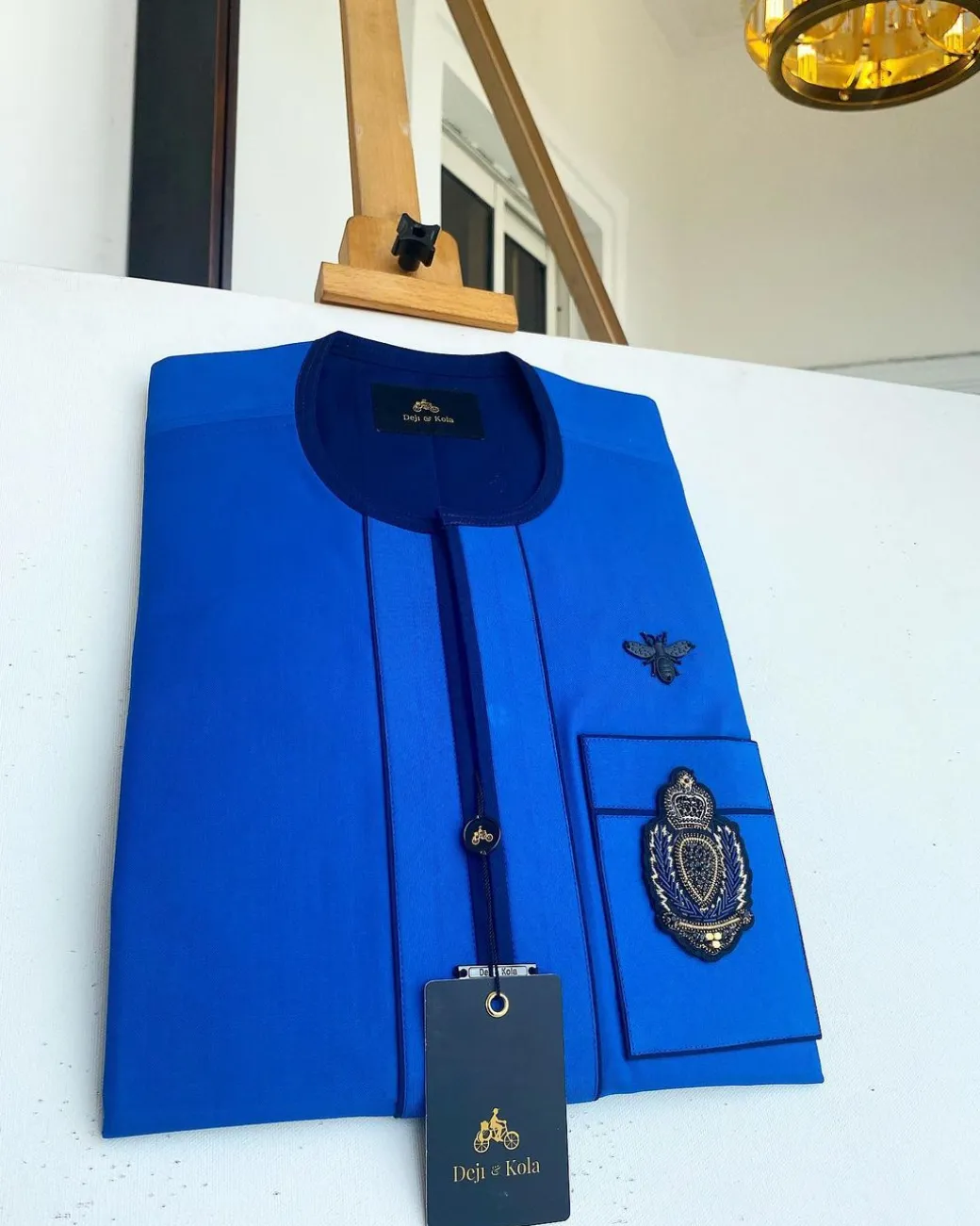 A Royal blue with navy blue mix, hand embroidery patch detailing, and black butterfly metal lapel African Kaftan