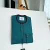 A Sacramento green, burgundy detailing, mixed-colour button details African traditional senator Kaftan native
