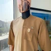 A Tortilla and peanut brown combat front and side pocket with a clear view of Swarovski stone detailing African traditional senator Kaftan native.