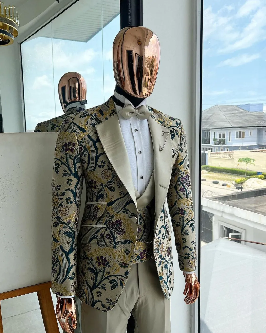 A Tortilla brown, emerald green, gold and splash of burgundy metallic floral jacquard peak lapel tuxedo suit