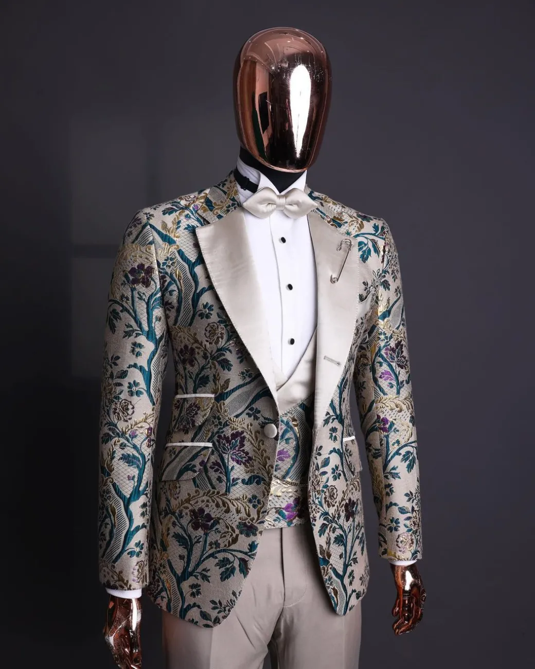 A Tortilla brown, emerald green, gold and splash of burgundy metallic floral jacquard peak lapel tuxedo suit