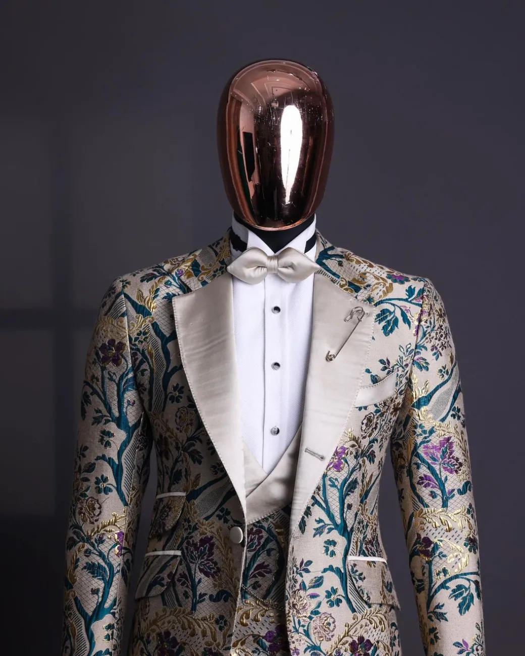 A Tortilla brown, emerald green, gold and splash of burgundy metallic floral jacquard peak lapel tuxedo suit