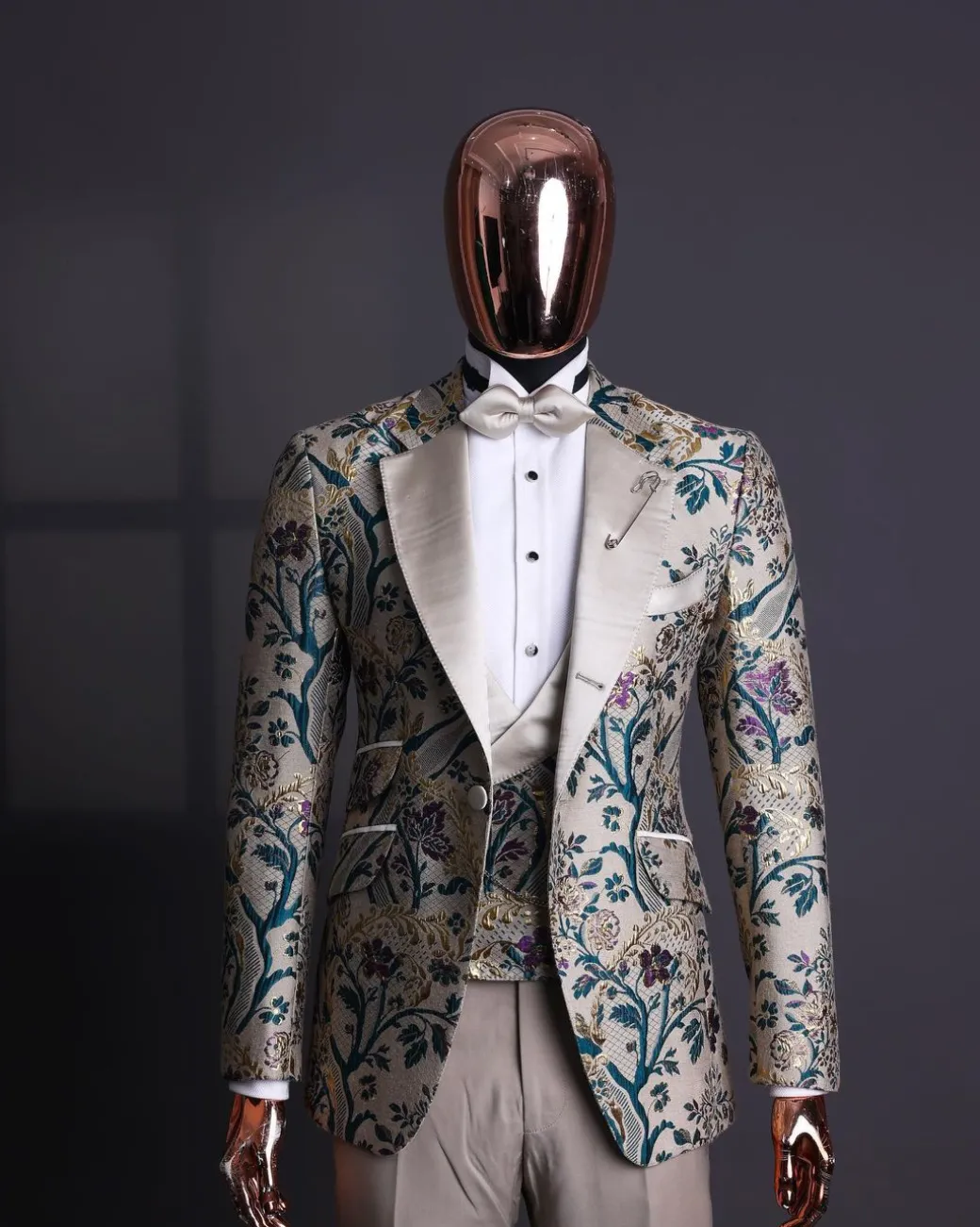 A Tortilla brown, emerald green, gold and splash of burgundy metallic floral jacquard peak lapel tuxedo suit